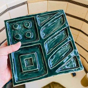 Likmat van keramiek gemaakt door Iris Floor Ceramics voor RAWR pets likmat voor honden en katten handgemaakt van keramiek. Hand houd de likmat vast boven de keramiek oven